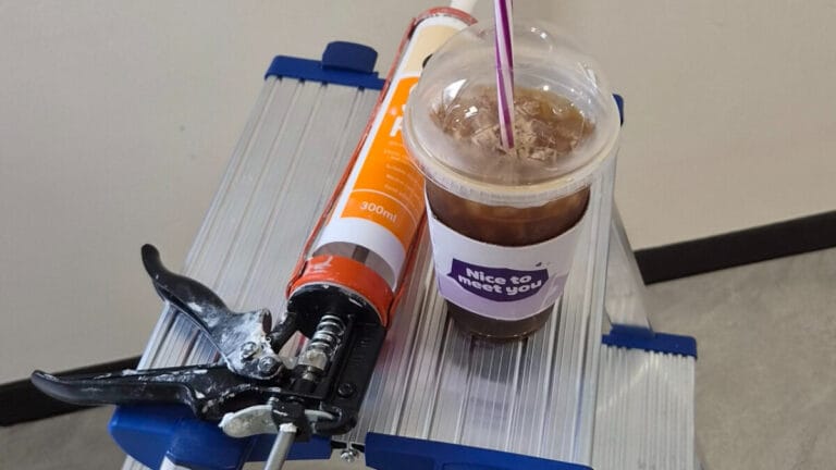 실리콘 시공 현장에서 실리콘 건 과 실리콘 그리고 커피가 함께 놓여있는 모습